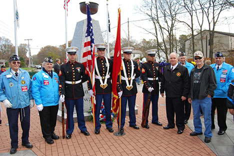 Mayor Allan M. Dorman (fourth from right) poses in front of the Islandia Veterans Memorial with local war veterans and members of The United States Marine Corps at the village's Veterans Day ceremony on November 10.