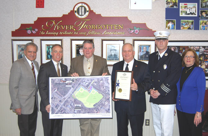 Suffolk County Legislator Tom Cilmi (second from left) and New York State Assemblyman Al Graf (third from left) hold up a rendering of the Village of Islandia First Responders Memorial Recreational Field while Mayor Allan M. Dorman (third from right), Village of Islandia, displays a certificate from New York Governor Andrew Cuomo’s office which grants ownership of the ball field to the village. Also pictured (l-r): Suffolk County Legislator Tom Muratore and Islandia Village Trustees Michael Zaleski and Patty Peters.