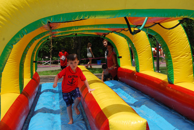 Gavin Schrage cools off as he runs through the water slide during the Village of Islandia’s 12th annual Bar-B-Que, which was held on July 15.