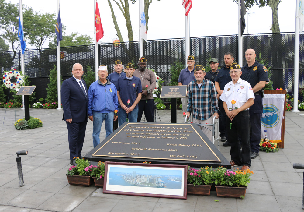 Mayor Allan M. Dorman (left) poses with members of the Col. Francis S. Midura Veterans of Foreign Wars Post #12144 and the Islandia Village safety officers at the new First Responders Memorial after a special dedication ceremony on September 11. The village remembered five local first responders who died during the 9/11 attacks.