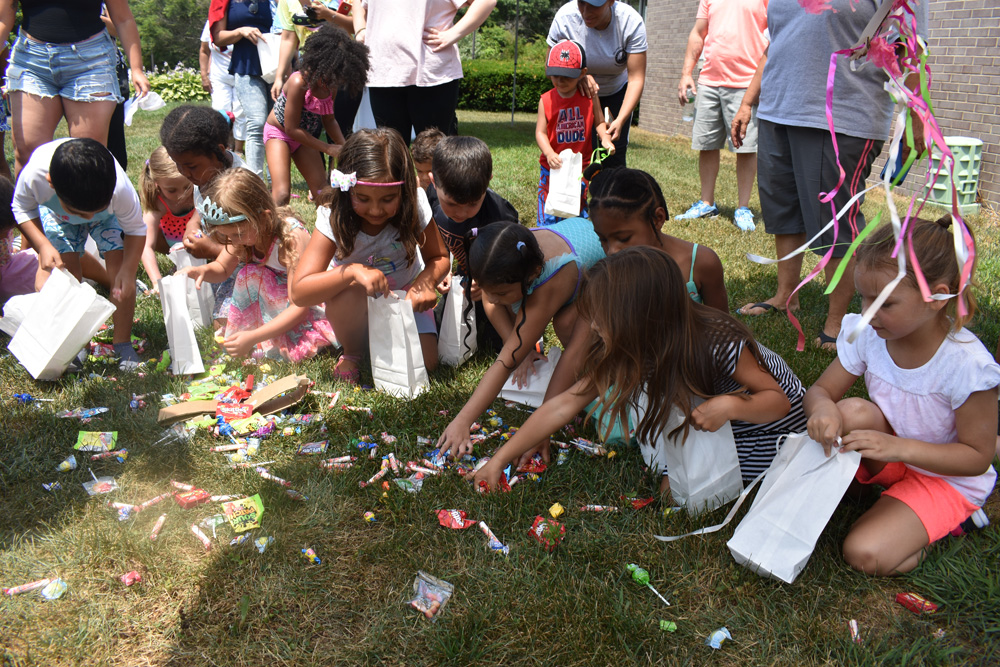 Children collect candy after breaking open the piñata at the Village of Islandia’s 13th Annual Bar-B-Que on July 14.