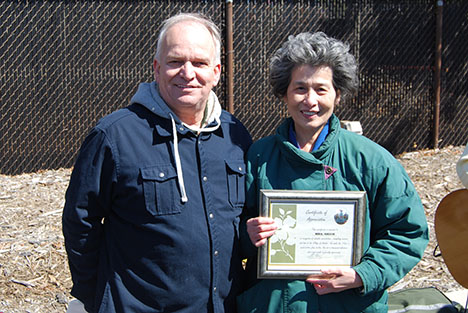 Mayor Allan M. Dorman (left) presents a certificate of appreciation to village resident Shy Main Shieh (right) in recognition of her volunteer work at all of the village's events at the 8th Annual Easter Egg Hunt on March 23.