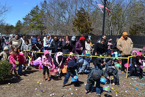 Children collect Easter eggs as their parents look on at the village's 8th annual Easter Egg hunt.