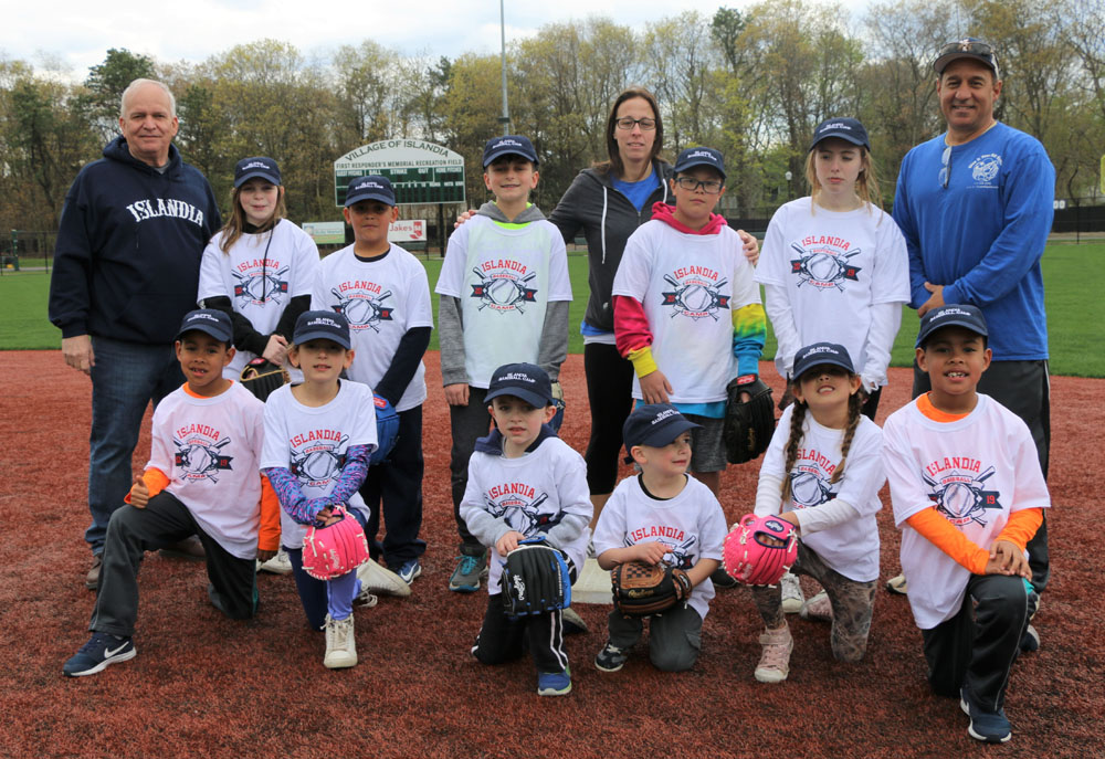 Allan M. Dorman (back row, left), Mayor, Village of Islandia, Denise Schrage (back row, center), Commissioner, Parks and Recreation, and Mike DiFilippo (back row, right), Owner, Give It Your All Sports, pose with the children who took part in the Islandia Baseball Camp at First Responders Recreational Ball Field on April 27.