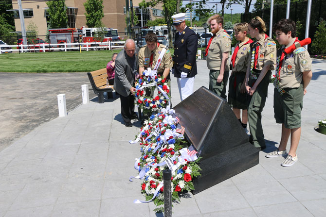 Allan M. Dorman (left), Mayor, Village of Islandia, is joined by Michael Zaleski (third from left), Deputy Mayor, Village of Islandia and Second Assistant Chief, Central Islip Fire Department, and members of Suffolk County Boy Scout Troop #272 in Ronkonkoma as they place a wreath at the memorial at First Responders Recreational Ball Field at a special ceremony on June 2.