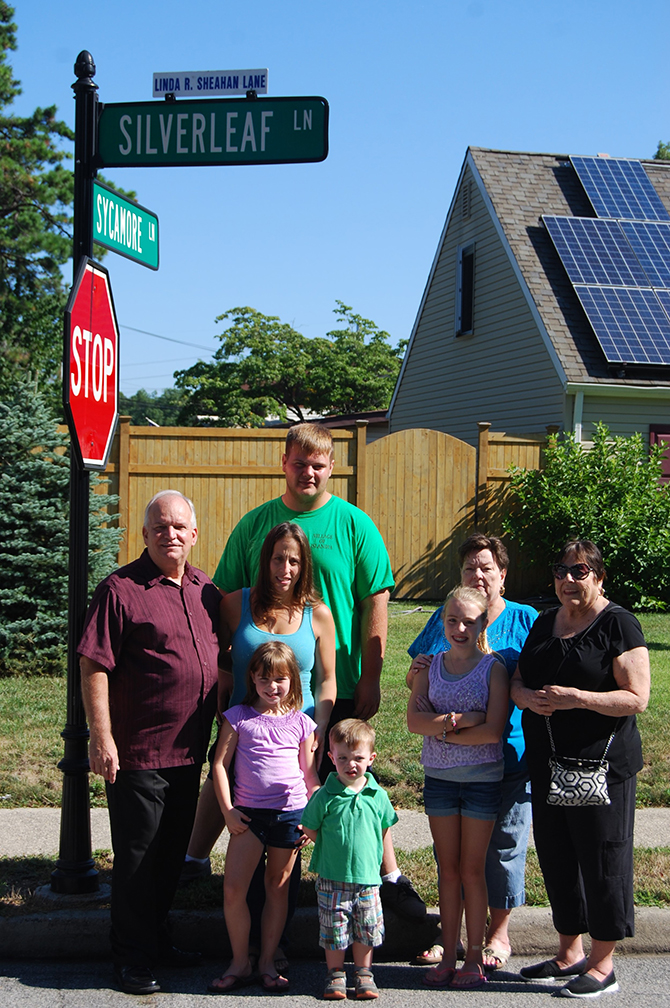 Mayor Allan M. Dorman (left), Village of Islandia, is joined by the family of Linda Sheahan, former Islandia Village Court Clerk, at a ceremony renaming Silverleaf Lane in her honor. Also pictured (l-r): Denise Schrage, Ms. Sheahan's daughter; Alyssa Schrage, Ms. Sheahan's granddaughter; Deputy Village Clerk Marilyn Griffaton and Florence Barrett, Ms. Sheahan's sisters. Standing in front of Ms. Schrage are Sophia Schrage (left) and Gavin Schrage (right), Ms. Sheahan's grandchildren. Standing behind Ms. Schrage: Justin Hinte, Ms. Sheahan's grandson.