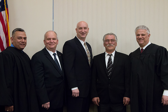 Mayor Allan M. Dorman (second from left), Deputy Mayor Mike Zaleski (center) and Village Trustee Burhan Kisla (second from right) were sworn in during a special ceremony on April 4 by Phil Goglas (left), Suffolk County Court Judge and Acting Family Court Judge, and Frank Tantone (right), Family Court Judge.