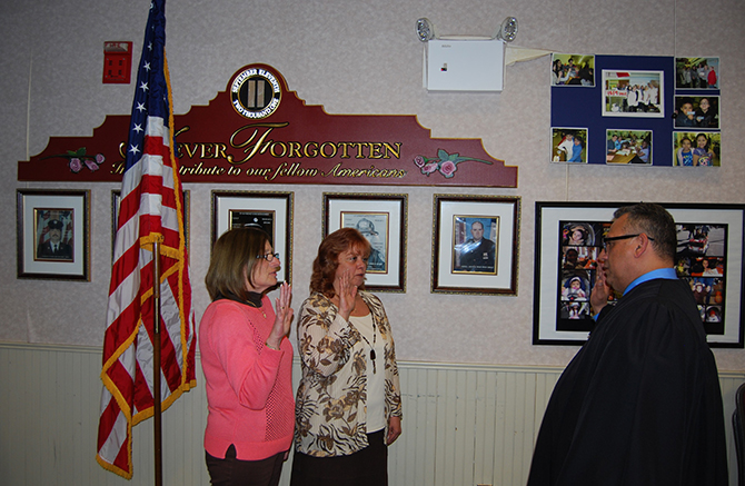 Phil Goglas (right), U.S. District Court Judge, swears in Patty Peters (left) and Barbara Lacey (center) for another term as Village Trustees at the Village Board meeting on April 7.