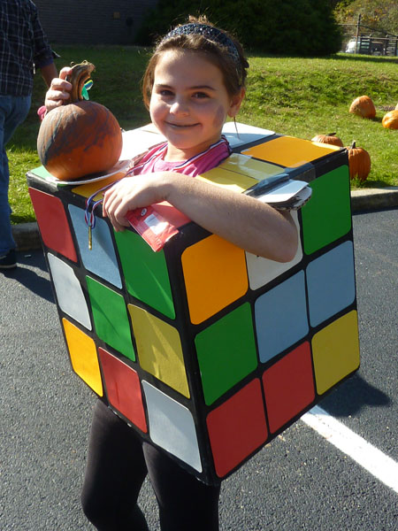 One of the children dressed as a Rubik’s cube displays a pumpkin she decorated.