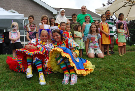 Allan M. Dorman (back row, right), Mayor, Village of Islandia, poses with the children who participated in the face painting contest, and the two clowns who entertained the children at the village's 5th annual Bar-B-Que.
