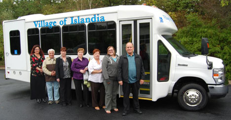 Islandia Village employees pose in front of the bus that the village recently purchased for senior citizens who need transportation.