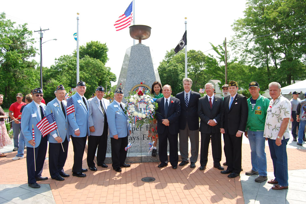 Allan Dorman (center, right), Mayor, Islandia Village, is joined in front of local war veterans and elected officials in front of the memorial after the village’s Memorial Day ceremony.