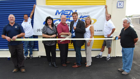 Mayor Allan M. Dorman (fourth from left) and John Beyer (fourth from right), President, Men On The Move, join in cutting the ribbon in celebration of Men On The Move's grand opening.