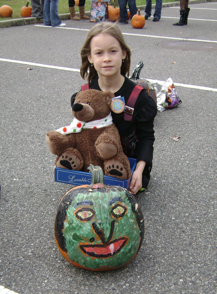 Eight-year-old Niaomi Gatley, winner of the pumpkin coloring contest, poses with her pumpkin and her prize at the Village of Islandia's 5th annual Craft Fair and Pumpkin Fest.