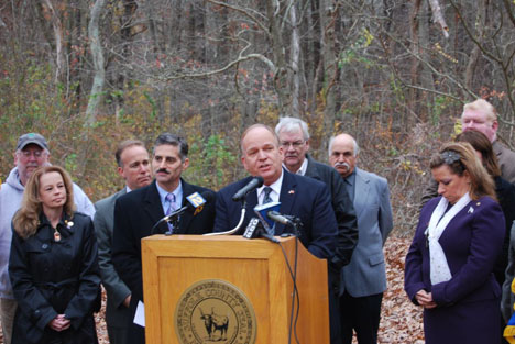 Allan M. Dorman (behind podium) addresses those in attendance at a ceremony announcing the creation of a Suffolk County Purple Heart Trail at Lakeland County Park in Islandia.