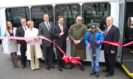 Islandia Village Mayor Allan M. Dorman (right) watches Helen Robacker (second from right) cut the ribbon to introduce the new handicapped-accessible bus Rides Unlimited of Nassau & Suffolk received on February 29.