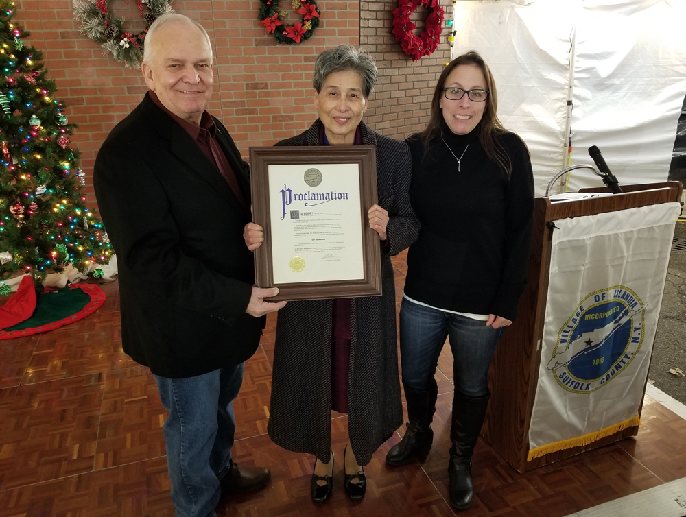 Allan M. Dorman (left), Mayor, Village of Islandia, honors local resident Shy Main Sheih (center) for her volunteer work at the village events during the village’s Good Neighbor Gala on December 5.