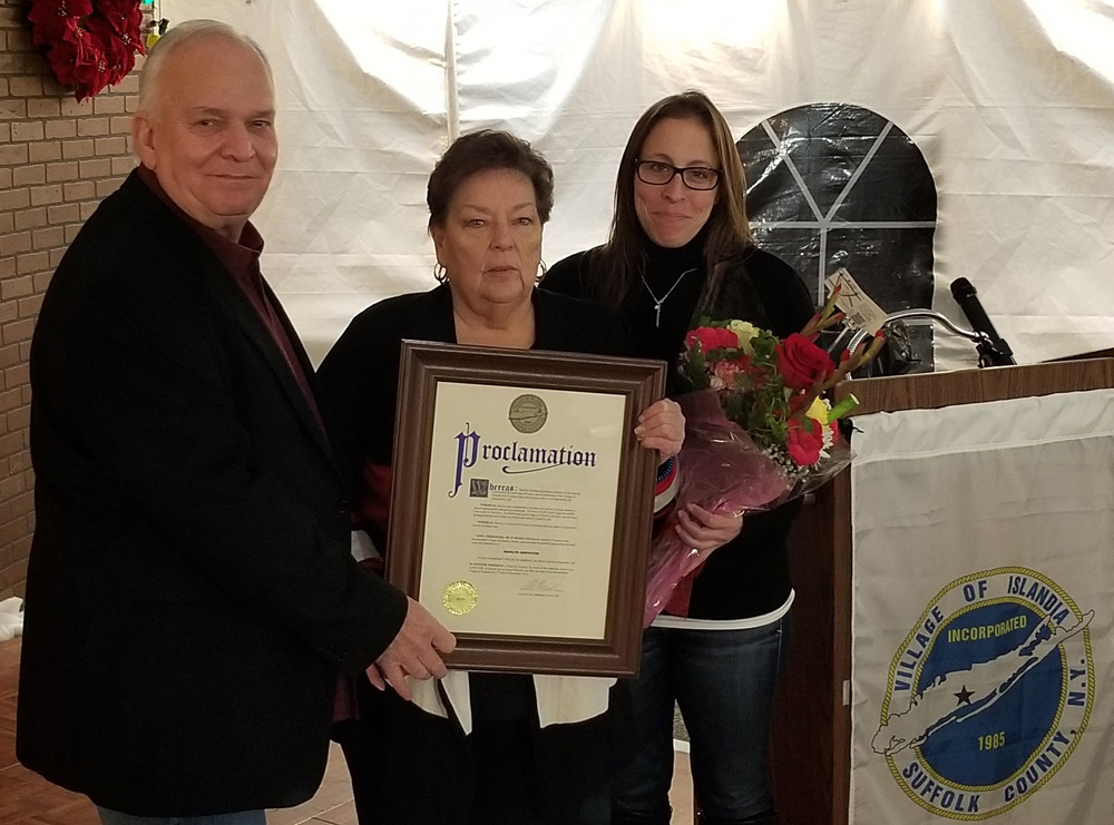 Marilyn Griffaton (center), Islandia Village Administrator, accepts a proclamation from Allan M. Dorman (left), Mayor, Village of Islandia, and Denise Schrage (right), Commissioner, Parks and Recreation and Ms. Griffaton’s niece, at the village’s Good Neighbor Gala on December 5.