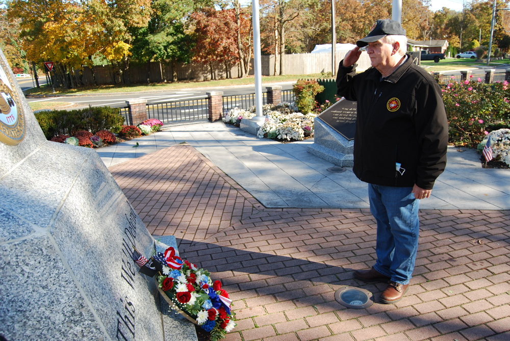 Allan M. Dorman, Mayor, Village of Islandia, salutes after laying a wreath in front of the Veterans Memorial at the Veterans Day wreath laying ceremony on November 7.